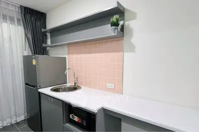 Modern kitchen with sleek gray cabinets and pink tile backsplash