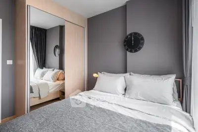 Modern bedroom with stylish decor and mirrored wardrobe