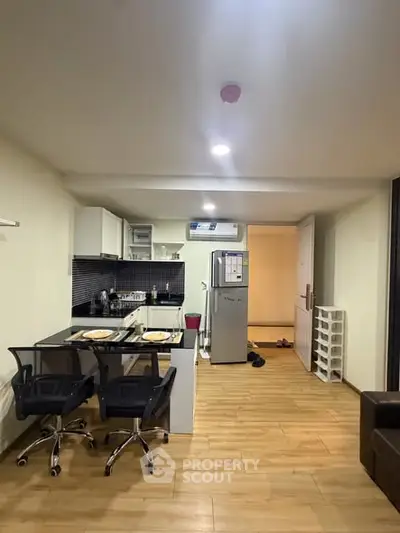 Modern kitchen with open layout and stylish dining area in a cozy apartment.