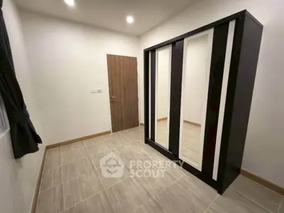 Spacious room with modern wardrobe and sleek tile flooring, perfect for stylish living.