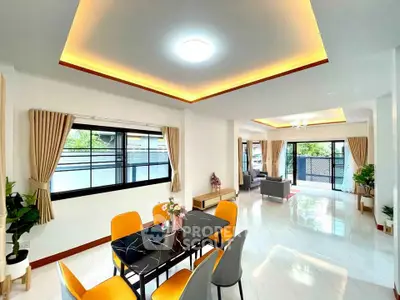 Spacious modern living and dining area with elegant lighting and large windows