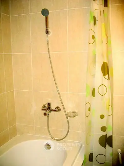 Modern bathroom with tiled walls and shower over bathtub