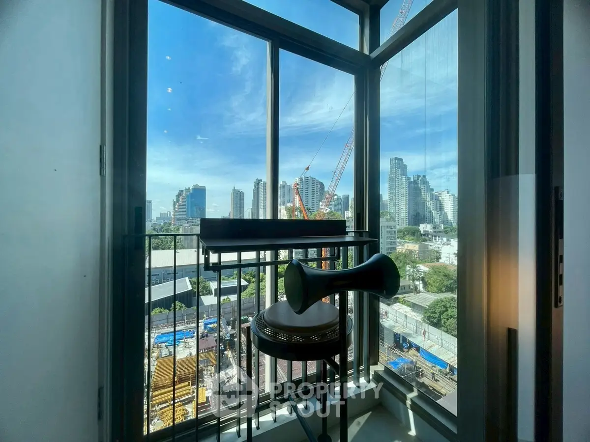 Stunning city view from modern apartment balcony with construction in progress.