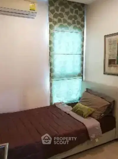 Cozy bedroom with single bed and stylish window treatment in modern apartment.