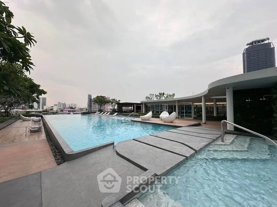 Luxurious rooftop pool with city skyline view and modern seating area.