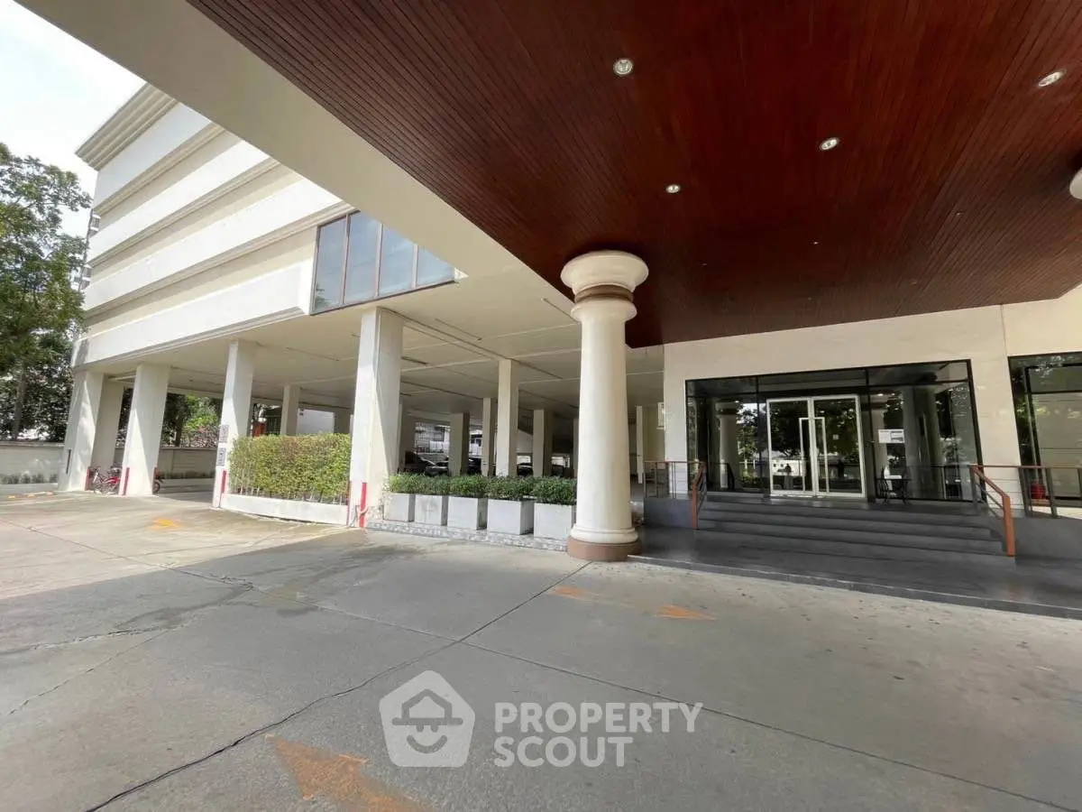 Modern building entrance with sleek design and spacious driveway