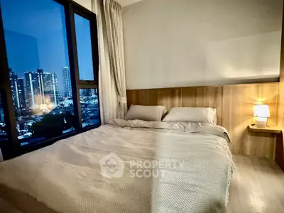 Cozy bedroom with city view, featuring a large window and elegant lighting, perfect for urban living.