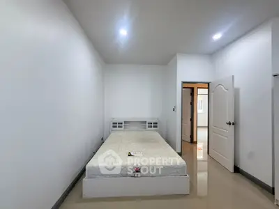 Spacious minimalist bedroom with modern design and ample natural light.