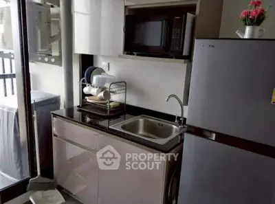 Modern compact kitchen with sleek appliances and balcony view