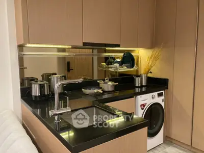 Modern kitchen with sleek design, featuring integrated appliances, under-cabinet lighting, and a washing machine, perfect for urban living.