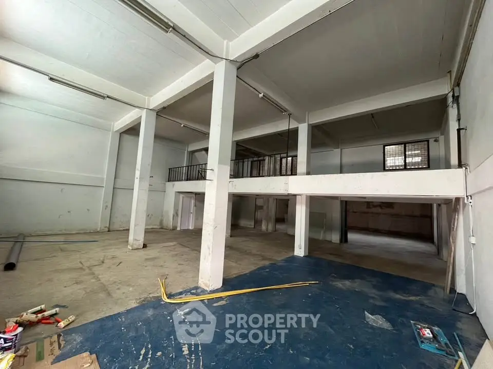 Spacious industrial warehouse with high ceilings and mezzanine level, ideal for storage or manufacturing.