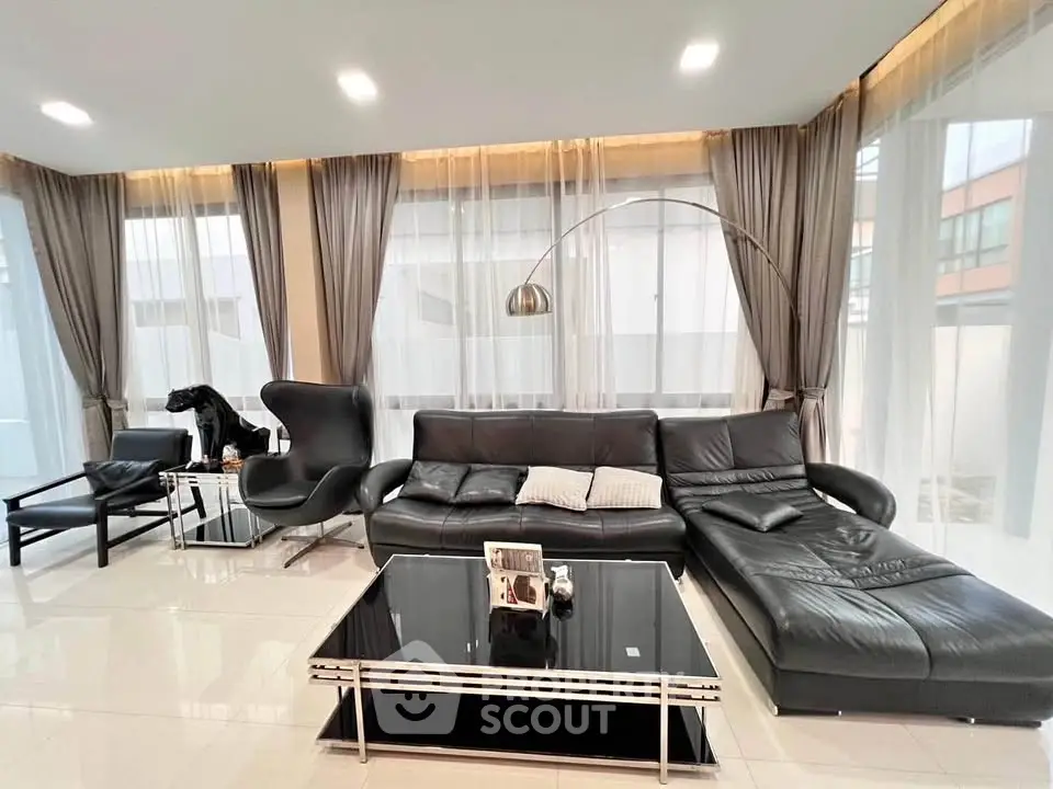 Luxurious modern living room with sleek black leather furniture and elegant decor