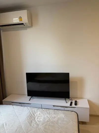 Modern living room with sleek TV setup and air conditioning unit