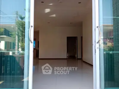 Spacious empty room with large glass doors and natural light, ideal for customization.