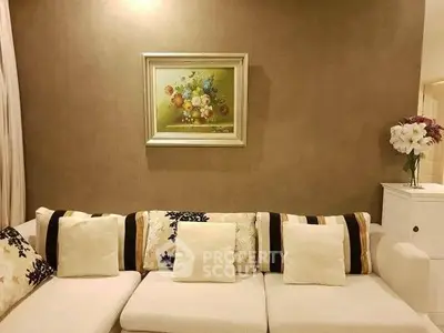 Elegant living room with stylish sofa and floral artwork enhancing cozy ambiance.