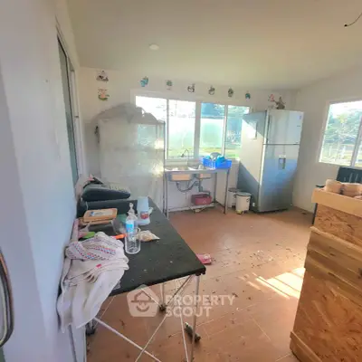 Cozy kitchen with large windows and modern fridge, offering a bright and airy atmosphere.