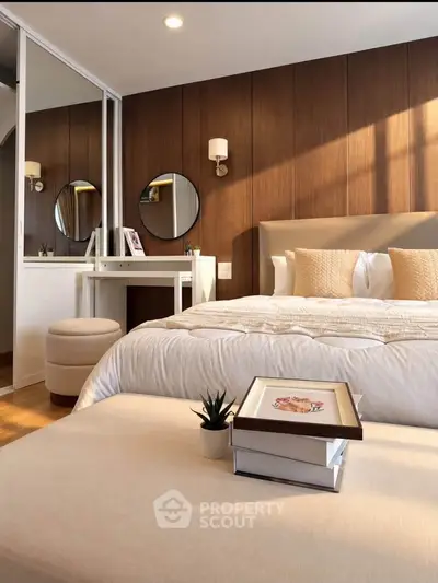 Luxurious bedroom with elegant decor and cozy ambiance, featuring a stylish vanity and plush bedding.
