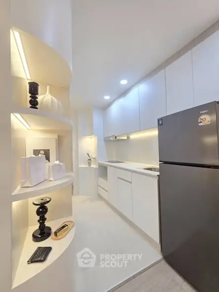 Modern kitchen with sleek white cabinets and stainless steel fridge