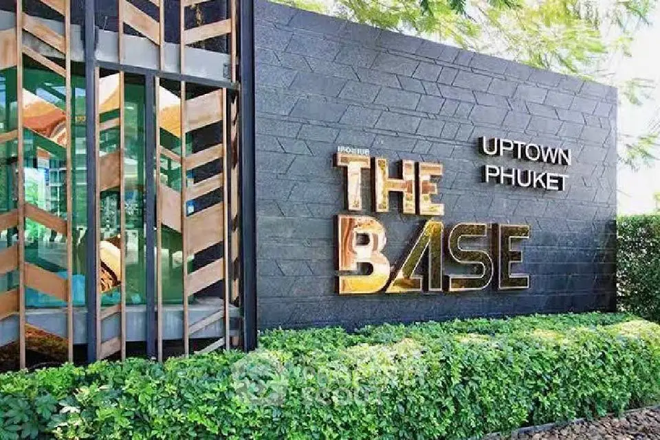 Modern exterior of The Base Uptown Phuket with lush greenery and stylish signage.