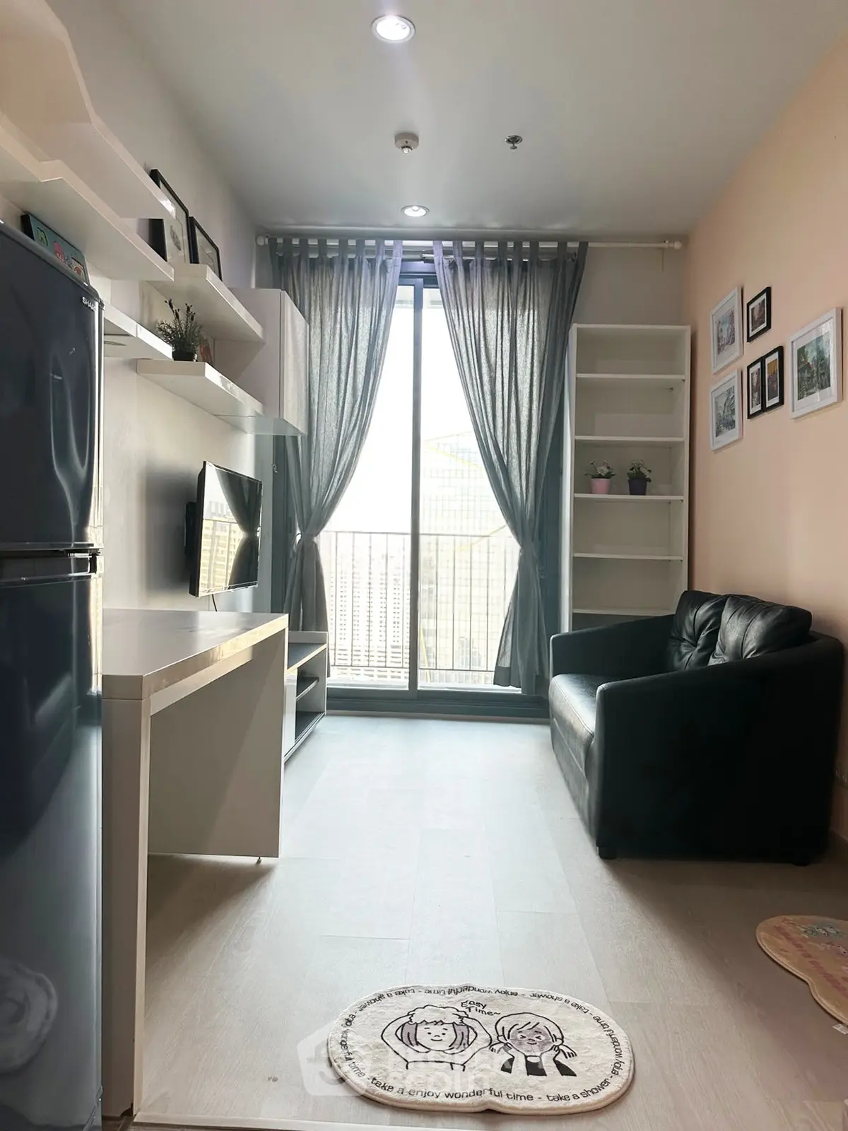 Modern living room with balcony access, featuring sleek furniture and abundant natural light.