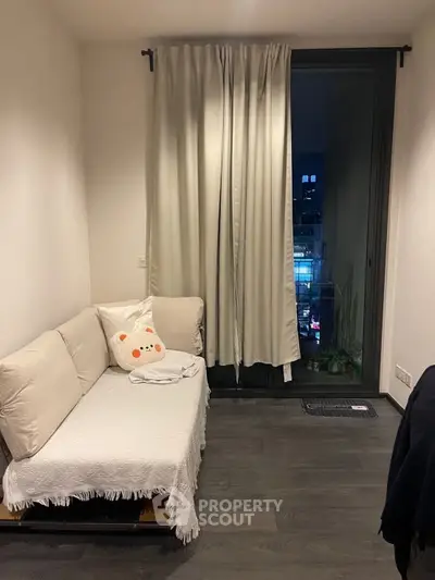 Cozy living room with modern decor and city view from large window.