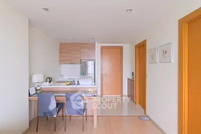 Modern kitchen with wooden cabinets and dining area in a cozy apartment
