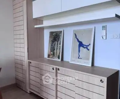 Stylish modern storage unit with framed art in a contemporary interior setting.
