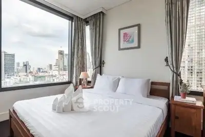 Luxurious bedroom with stunning city view and elegant decor in high-rise apartment.