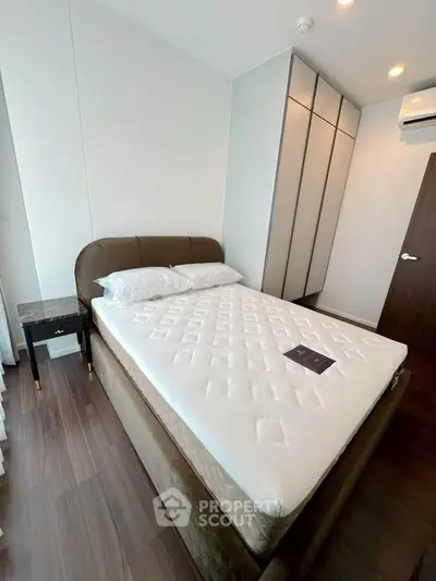 Modern bedroom with stylish bed and sleek wardrobe in a contemporary apartment.