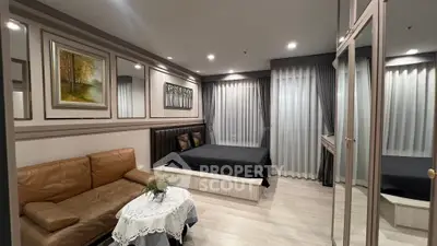 Modern bedroom with elegant decor and cozy seating area, featuring stylish artwork and ambient lighting.