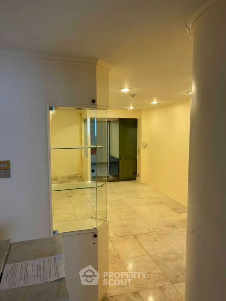 Spacious hallway with marble flooring and built-in glass shelves