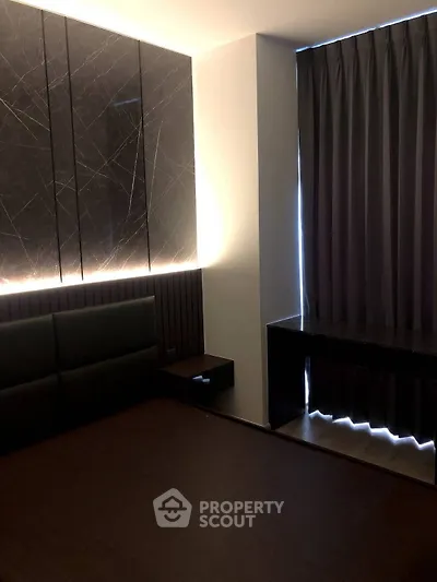 Modern bedroom with elegant dark decor and ambient lighting