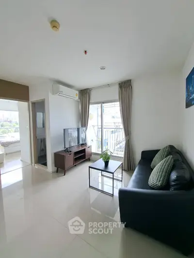 Spacious modern living room with sleek furniture and city view balcony.