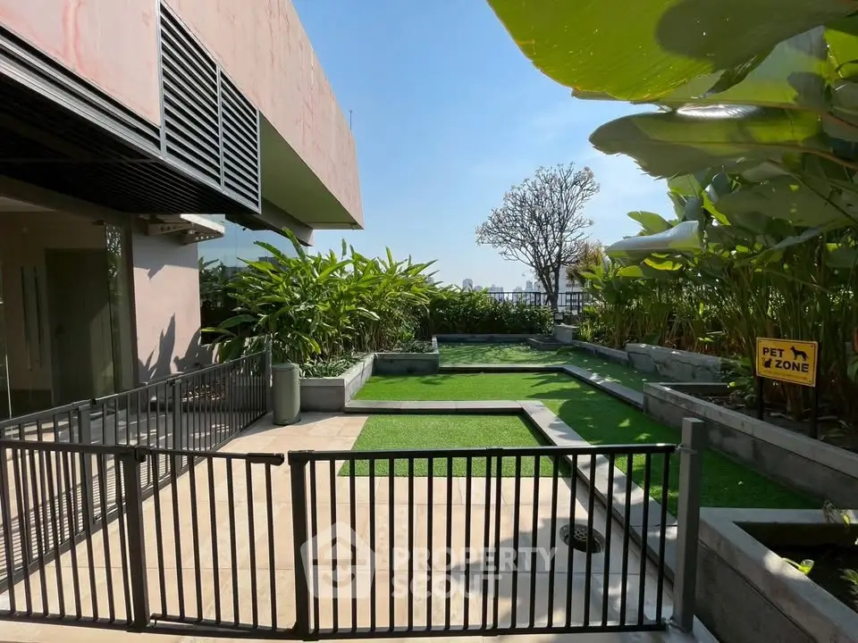 Modern pet-friendly outdoor area with lush greenery and secure fencing in a contemporary building.