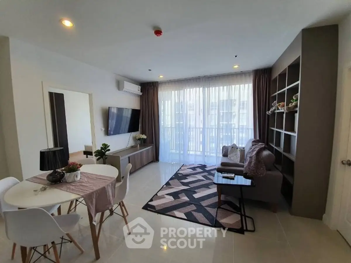Modern living room with stylish decor and large window, perfect for relaxation.