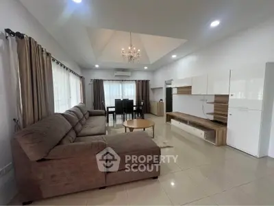 Spacious modern living room with elegant chandelier and cozy sectional sofa