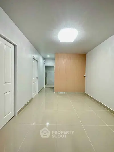 Spacious and modern interior with sleek tile flooring and bright lighting, perfect for versatile living.