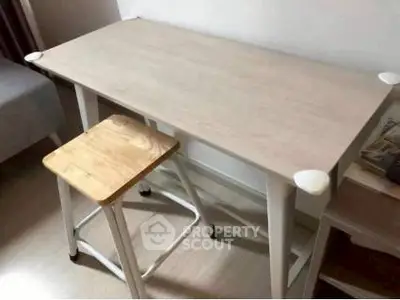 Modern minimalist study desk with stool in a cozy interior setting.
