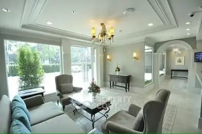 Elegant living room with large windows and stylish furniture, perfect for relaxation and entertaining.