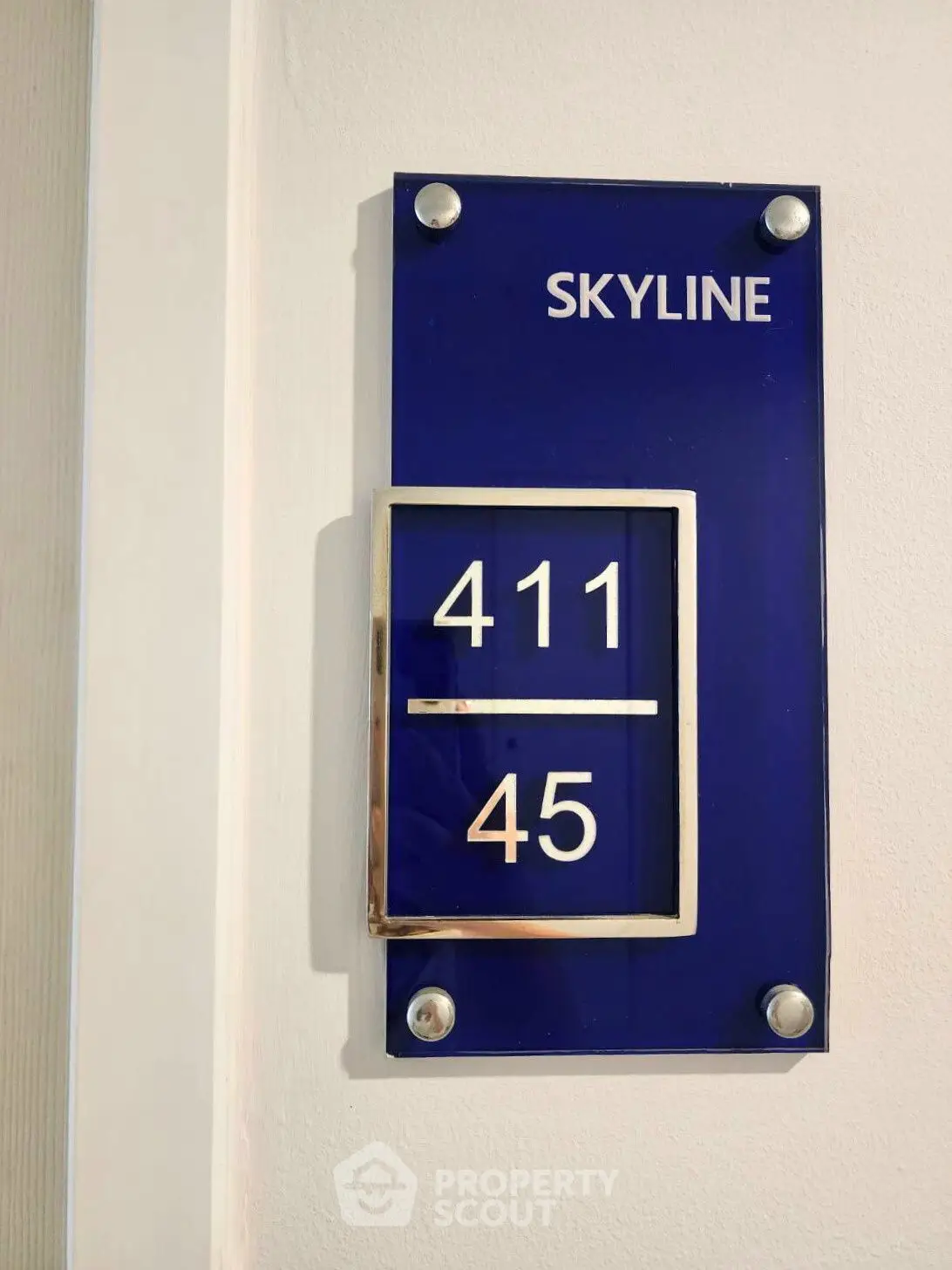 Modern apartment number sign with sleek design and blue background.