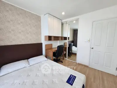 Modern bedroom with stylish decor and workspace, featuring a comfortable bed and mirrored wardrobe.