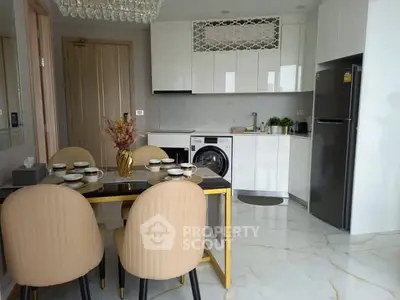 Modern kitchen with dining area, featuring sleek appliances and elegant decor.