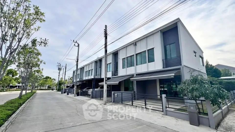 Modern townhouse exterior with sleek design and spacious driveway in a serene neighborhood.
