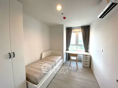 Modern minimalist bedroom with single bed, desk, and large window offering city view.