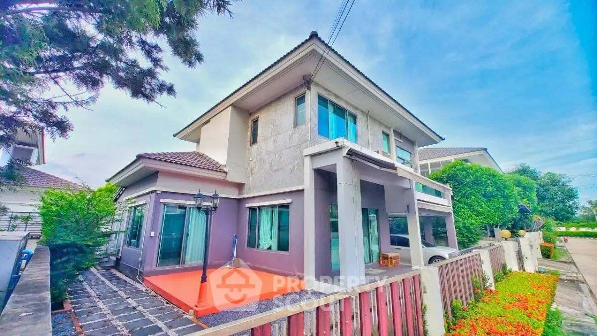 Modern two-story house with spacious driveway and lush garden in suburban neighborhood.