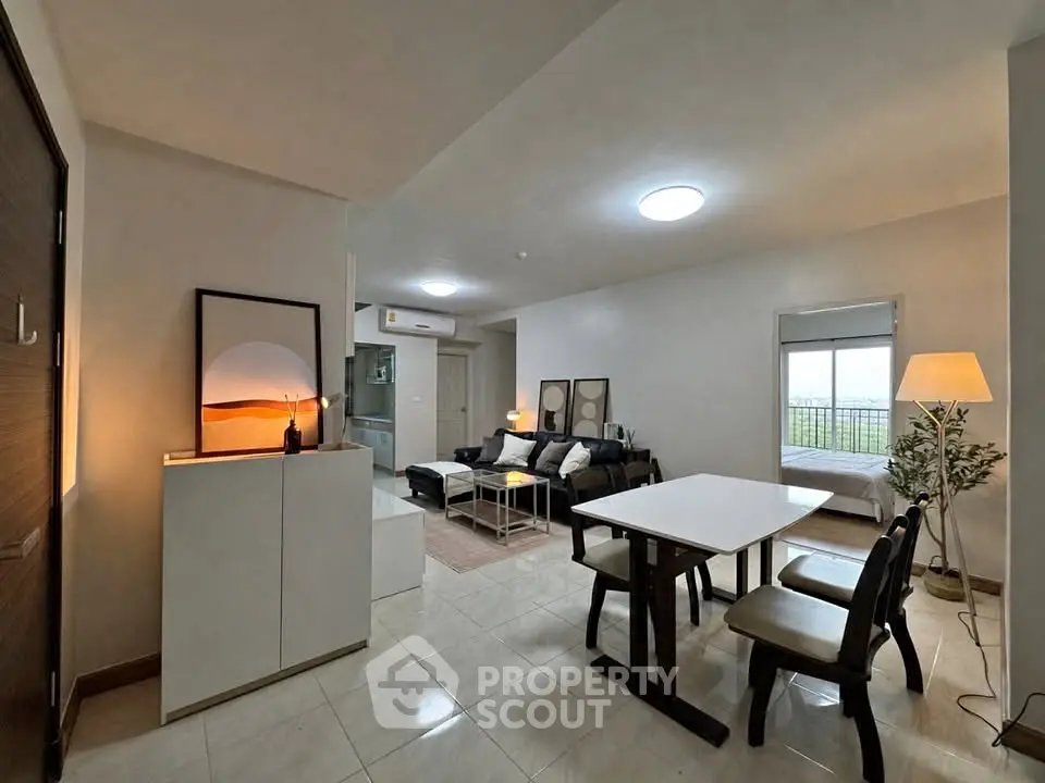 Modern open-plan living room with dining area and cozy bedroom view