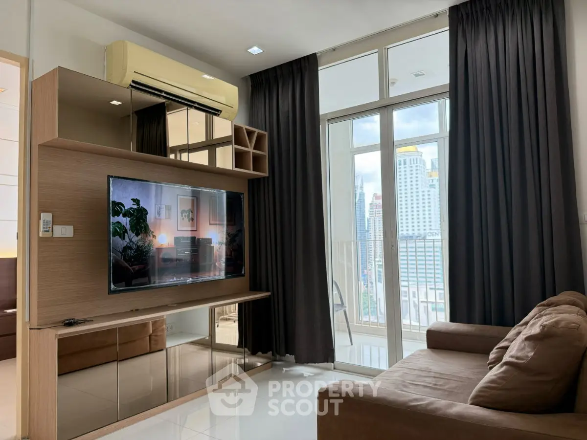 Modern living room with city view, featuring sleek furniture and large windows for natural light.