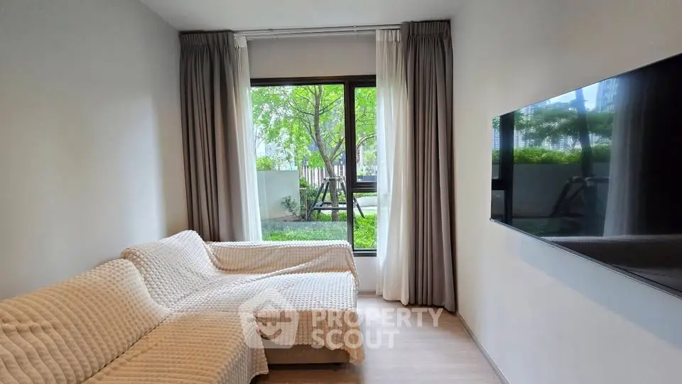Modern living room with large window and cozy sofa, offering a serene garden view.