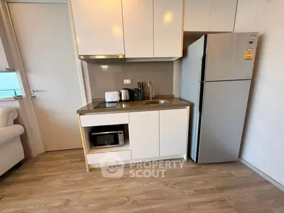Modern compact kitchen with sleek appliances and stylish cabinetry in a cozy apartment setting.