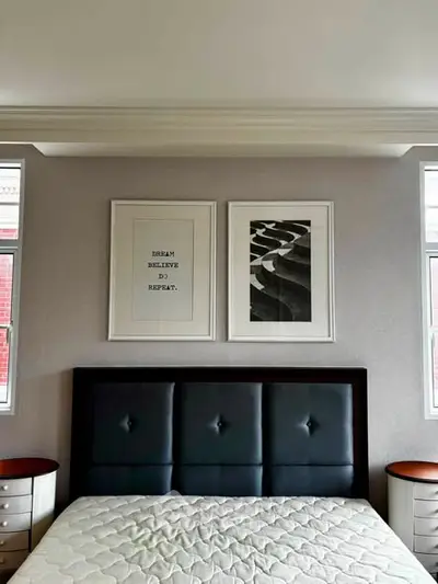 Elegant bedroom with modern decor and stylish artwork above a plush bed, perfect for relaxation.